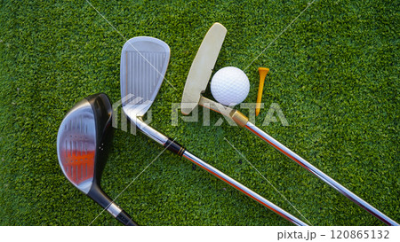 Golf clubs and golf balls on a green lawn in a beautiful golf course with morning sunshine. Golf clubs and golf balls on a green lawn in a beautiful golf course with morning sunshine. 120865132