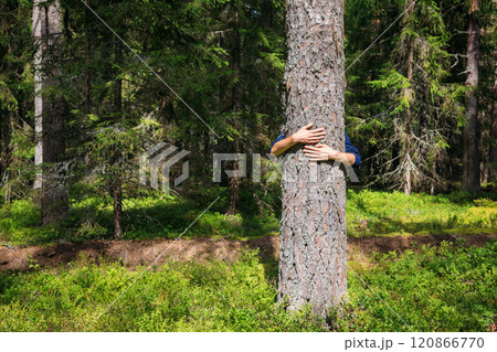 Teen boy hugs tree in a forest promoting environmental care and connection with nature 120866770