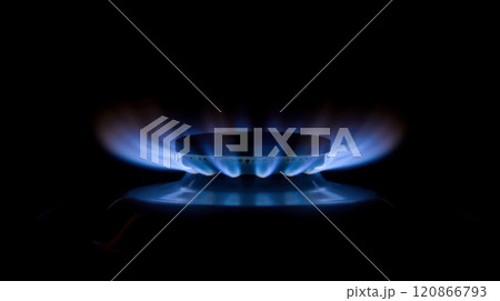 Blue gas flame burning on stove in dark background, high gas prices, natural fuel use, household expenses, and energy crisis, representing economy, heating, resource management 120866793