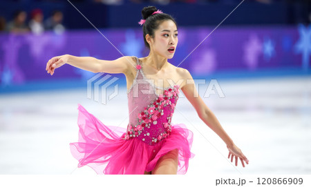 Figure skater performing on ice in competition, showcasing elegance and skill in beautiful pink costume. female Athlete gliding across rink, executing complex routine with grace and precision 120866909