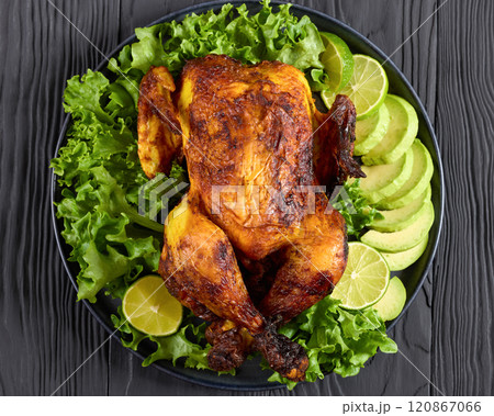 whole roasted chicken with avocado, lime on plate 120867066