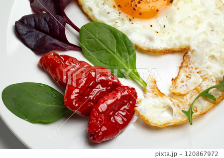 Fried egg and dried tomatoes on the plate. Fried egg and dried tomatoes on the plate. 120867972