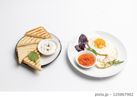 Fried egg on the plate and toasts with cheese sauce. 120867982
