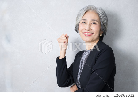 ガッツポーズをするスーツを着たグレイヘアのシニア女性社長の様なカッコイイビジネスイメージ カメラ目線 ガッツポーズをするスーツを着たグレイヘアのシニア女性社長の様なカッコイイビジネスイメージ カメラ目線 120868012