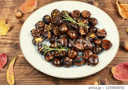 Cracked roasted chestnuts on rustic wooden table. Cracked roasted chestnuts on rustic wooden table. 120869092