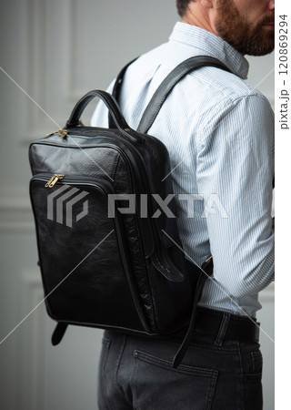 A Stylish and Professional Man Standing with a Bag in a Contemporary Modern Setting A Stylish and Professional Man Standing with a Bag in a Contemporary Modern Setting 120869294