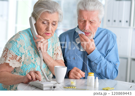 An elderly couple is sick and takes medication at home 120869443