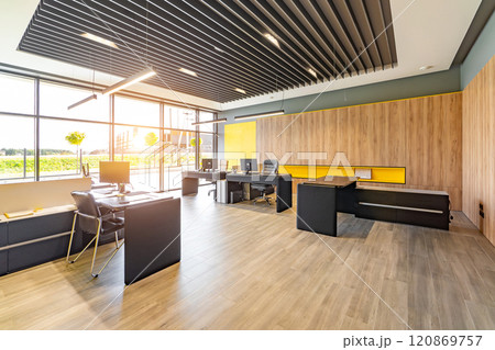 Modern office space with tables and chairs, computers and office supplies with no employees 120869757