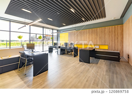 Modern office space with tables and chairs, computers and office supplies with no employees 120869758