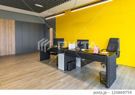Modern office space with tables and chairs, computers and office supplies with no employees 120869759