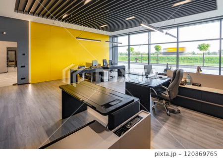 Modern office space with tables and chairs, computers and office supplies with no employees Modern office space with tables and chairs, computers and office supplies with no employees 120869765