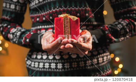 Man holds red Christmas gift package Man holds red Christmas gift package 120870418