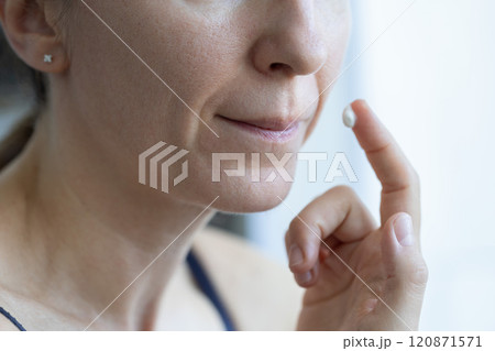 Woman applying anti agin cream on wrinkles on her face. Closeup. Skin care. 120871571
