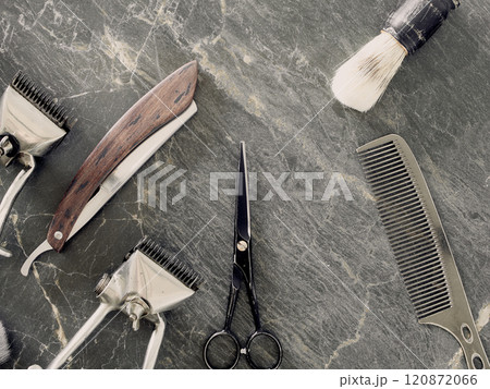 On a grey marble surface are old barber tools. Vintage manual hair clipper comb razor shaving brush shaving brush hairdressing scissors. top view. flat lay. On a grey marble surface are old barber tools. Vintage manual hair clipper comb razor shaving brush shaving brush hairdressing scissors. top view. flat lay. 120872066