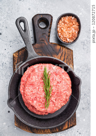 Ready for cooking Raw beef meat patties, cutlets with herbs in pan. grey background. top view 120872715