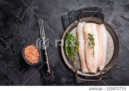 Raw Loin cod fish fillets ready for cooking whitefish in stell tray. black background. top view Raw Loin cod fish fillets ready for cooking whitefish in stell tray. black background. top view 120872719