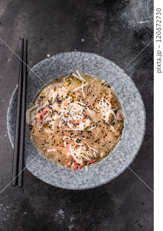 Wok with glass noodles, spicy peanut dressing, meat and vegetables. black background. top view Wok with glass noodles, spicy peanut dressing, meat and vegetables. black background. top view 120872730