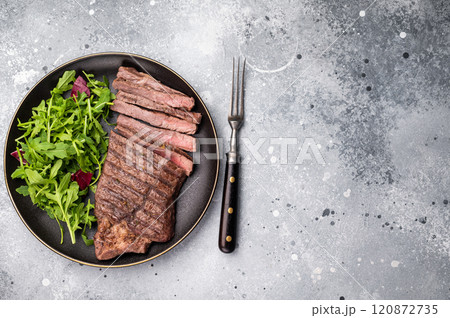 Barbecue dry aged wagyu entrecot steak on plate with salad. grey background. top view 120872735