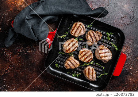 Fried pork medallions steaks from tenderloin meat on a grill skillet. Dark background. Top view 120872782