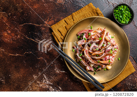 Asian appetizer pig pork ears with sesame seeds, green onion and spicy sauce. Dark background. Top view. Copy space Asian appetizer pig pork ears with sesame seeds, green onion and spicy sauce. Dark background. Top view. Copy space 120872820
