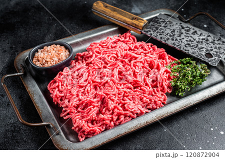 Unccoked Mince Ground meat, raw mincemeat beef and pork in a kitchen tray. Black background. Top view Unccoked Mince Ground meat, raw mincemeat beef and pork in a kitchen tray. Black background. Top view 120872904