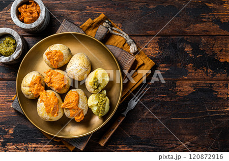 Canary Islands dish Papas Arrugadas wrinkly salty potatoes with and Mojo picon red spicy sauce. Wooden background. Top view. Copy space Canary Islands dish Papas Arrugadas wrinkly salty potatoes with and Mojo picon red spicy sauce. Wooden background. Top view. Copy space 120872916