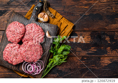 Fresh Raw burger patty, mince beef Meat, uncooked meat cutlets. Wooden background. Top view. Space for text 120872919