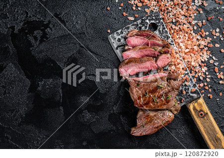 Sliced grilled Lamb fillet steak, mutton meat from leg. Black background. Top view. Copy space 120872920