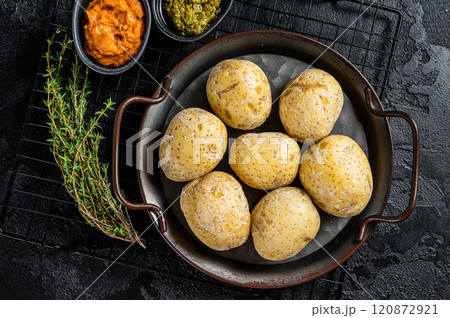 Canarian potatoes papas arrugadas with mojo, hot sauce. Black background. Top view 120872921