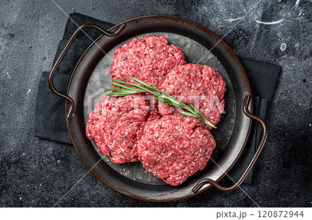 Uncooked Frikadellen from Mince beef Meat, raw meat cutlets. Black background. Top view 120872944
