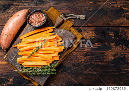 Sweet potatoes on a cutting board, fresh batata french fries ready for cooking. Wooden background. Top view. Copy space Sweet potatoes on a cutting board, fresh batata french fries ready for cooking. Wooden background. Top view. Copy space 120872986
