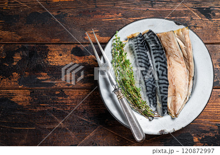 Salty sliced mackerel fillet fish in a plate with herbs. Wooden background. Top view. Copy space 120872997