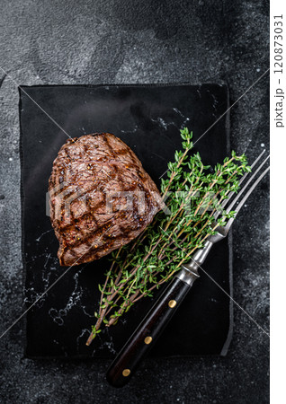 Grilled Rump steak with spices, cooked beef meat. Black background. Top view 120873031
