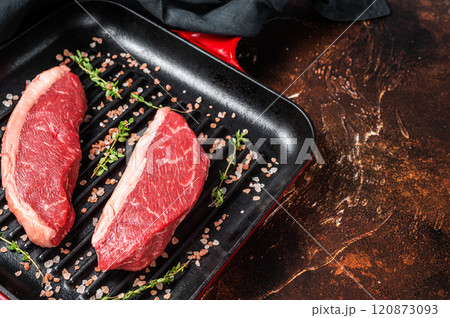 Raw Cap Rump steak, marbled beef meat on a grill skillet. Dark background. Top view. Copy space 120873093