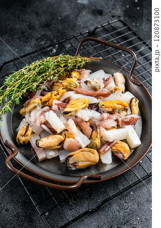 Raw Seafood mix, sea cocktail of fresh mussels, clams, squid, octopus, shrimps and prawn. Black background. Top view Raw Seafood mix, sea cocktail of fresh mussels, clams, squid, octopus, shrimps and prawn. Black background. Top view 120873100