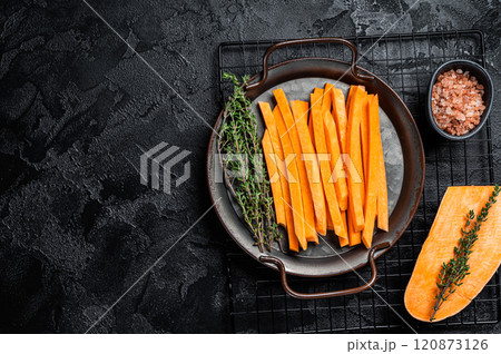 Sliced Sweet potatoes in a steel tray, fresh batata fries ready for cooking. Black background. Top view. Copy space Sliced Sweet potatoes in a steel tray, fresh batata fries ready for cooking. Black background. Top view. Copy space 120873126