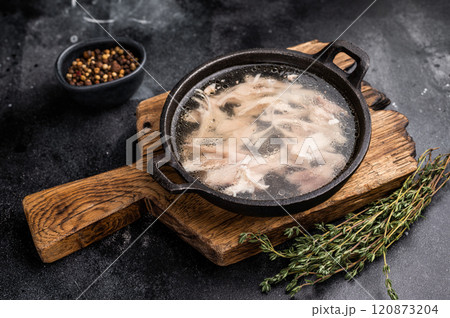 Chicken broth with meat, chicken soup in a skillet. black background. top view Chicken broth with meat, chicken soup in a skillet. black background. top view 120873204