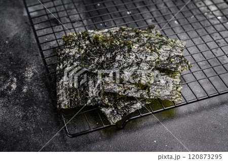 Dried Nori seaweed sheets on a rack. black background. top view Dried Nori seaweed sheets on a rack. black background. top view 120873295