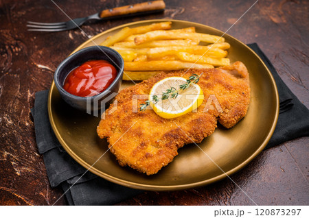 Wiener pork schnitzel steak, breaded meat with french fry on a plate. brown background. top view 120873297