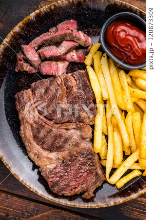 Dinner with grilled Chuck eye roll steak and french fry on a plate. wooden background. top view 120873309