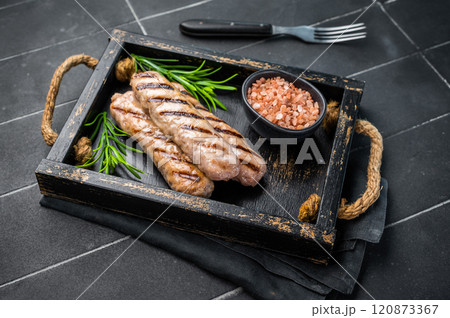 Roasted on BBQ beef and lamb sausages in wooden tray. black background. top view Roasted on BBQ beef and lamb sausages in wooden tray. black background. top view 120873367