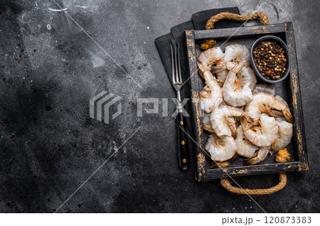 Fresh Raw headless tiger shrimps prawns in a tray. Top view. Black background Fresh Raw headless tiger shrimps prawns in a tray. Top view. Black background 120873383