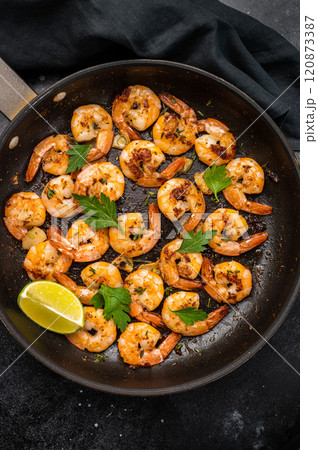 Fried Shrimps Prawns with garlic and butter in a skillet. Black background. Top view 120873387