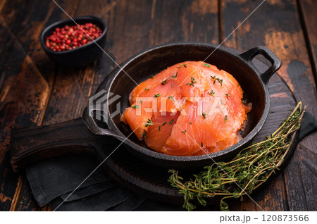 Salmon fillet slices with herbs in a skillet. wooden background. top view Salmon fillet slices with herbs in a skillet. wooden background. top view 120873566