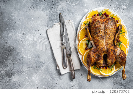 Christmas roast duck with apples and oranges, festive christmas recipe. Gray background. Top view. Copy space Christmas roast duck with apples and oranges, festive christmas recipe. Gray background. Top view. Copy space 120873702