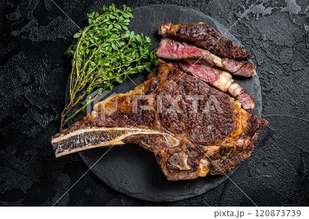Roasted Tomahawk or cowboy with bone beef meat steak. Black background. Top view Roasted Tomahawk or cowboy with bone beef meat steak. Black background. Top view 120873739