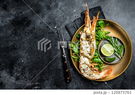 Grilled Spiny lobster with salad on a plate. Black background. Top view. Copy space Grilled Spiny lobster with salad on a plate. Black background. Top view. Copy space 120873761