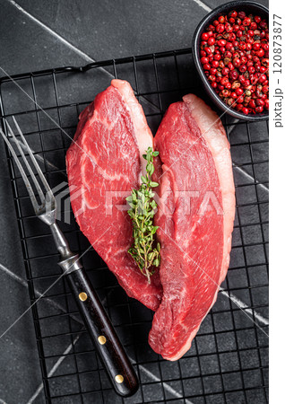 Sirloin steak or Cap Rump, raw beef meat with herbs on a rack. Black background. Top view Sirloin steak or Cap Rump, raw beef meat with herbs on a rack. Black background. Top view 120873877