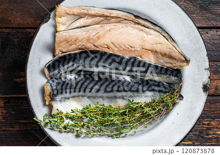 Salty sliced mackerel fillet fish in a plate with herbs. Wooden background. Top view 120873878