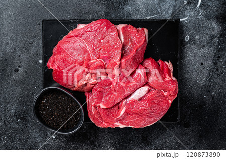 Raw Mutton fillet steaks from leg, uncooked lamb meat. Black background. Top view Raw Mutton fillet steaks from leg, uncooked lamb meat. Black background. Top view 120873890